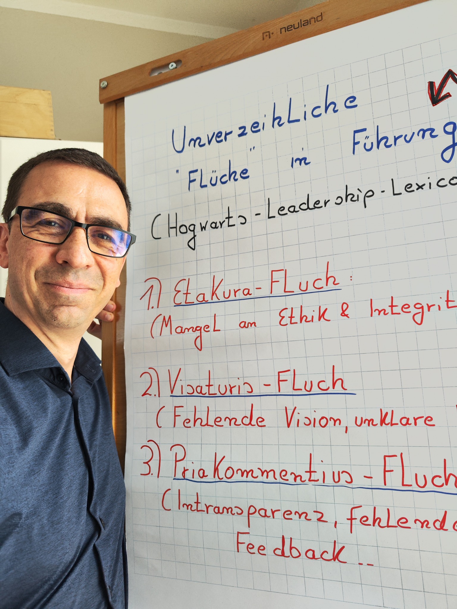 Oliver Wenning neben einem Flipchart zu Führung und Zusammenarbeit